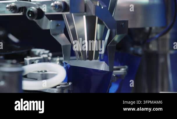 Industrial filling heads dispense cosmetic product into containers on ...