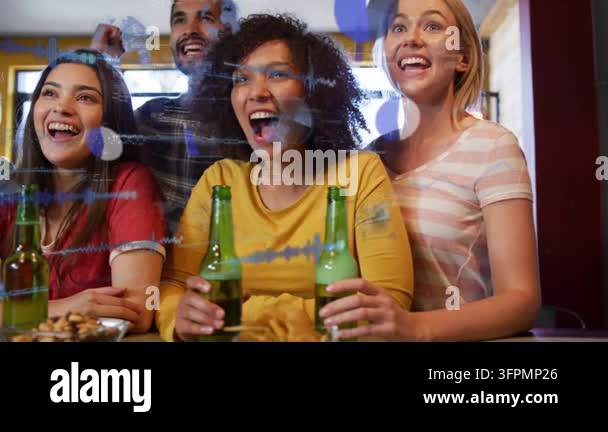 Friends cheering sports win, elbow bumping, pumping fist under blue ...
