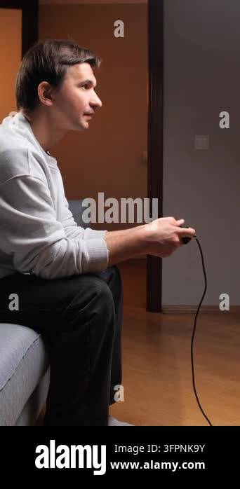 Playing Loop Vertical video happy man smiling, celebrating victory while playing ...