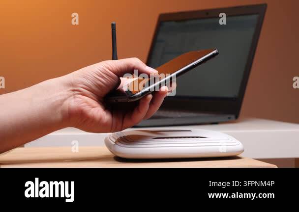 Persons hand holding a modern smartphone, connecting to a white wi fi ...