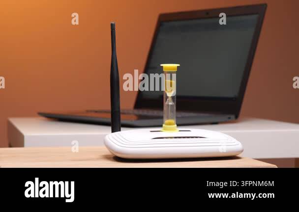 Hourglass with sand falling placed on a wireless internet router ...