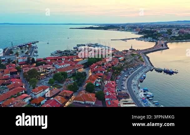 Photo Have Many Color A coastal town features many red rooftops along the shoreline. The ...