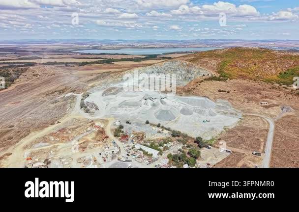 Large Area A large quarry site shows earth being moved and processed. Various ...