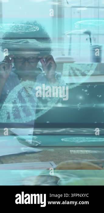Vertical video: Woman fixing specs leaning reading laptop docs as DNA ...