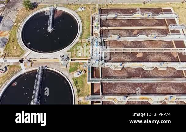 Large Area The scene depicts a wastewater treatment facility with large circular ...