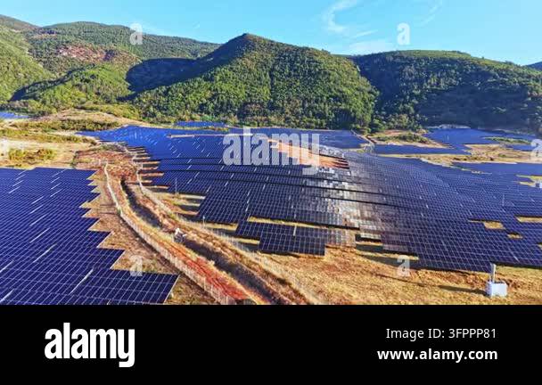 Large solar panel field located in a mountainous area with green trees ...