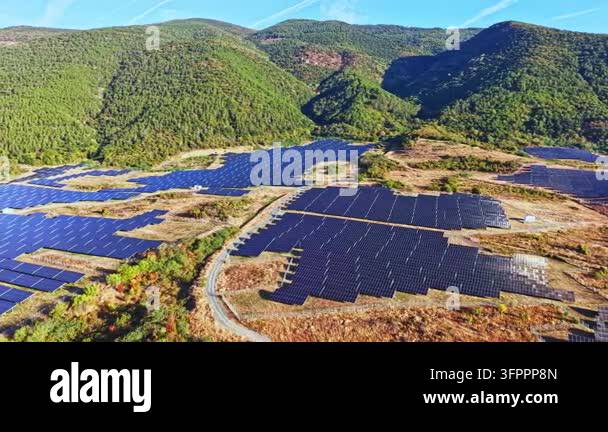 Large Area The scene shows a large solar panel farm in a valley surrounded by ...