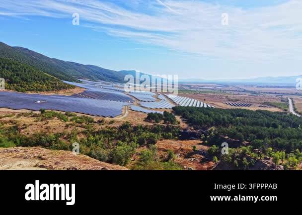 Large Area A large field of solar panels stretches across the hilly landscape. The ...