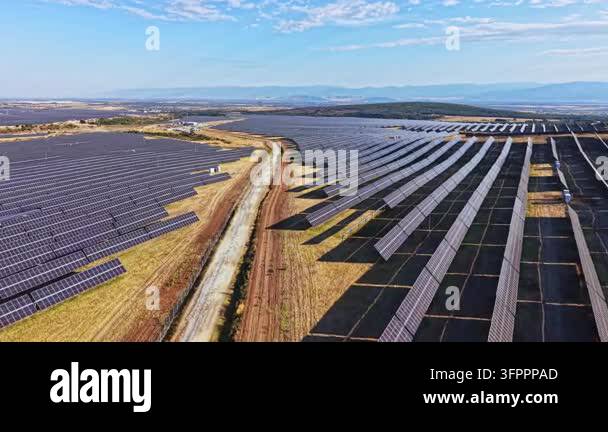 Rows of solar panels stretch across the landscape in a rural area ...