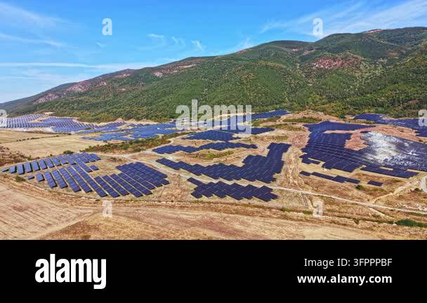 Farm Panel Pattern A large solar panel farm is spread across a hilly landscape. Rows of ...
