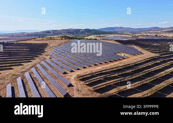 Large Area A large field is filled with solar panels arranged in rows under a ...