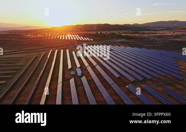 Large Area Rows of solar energy panels are set up in a large open area as the sun ...