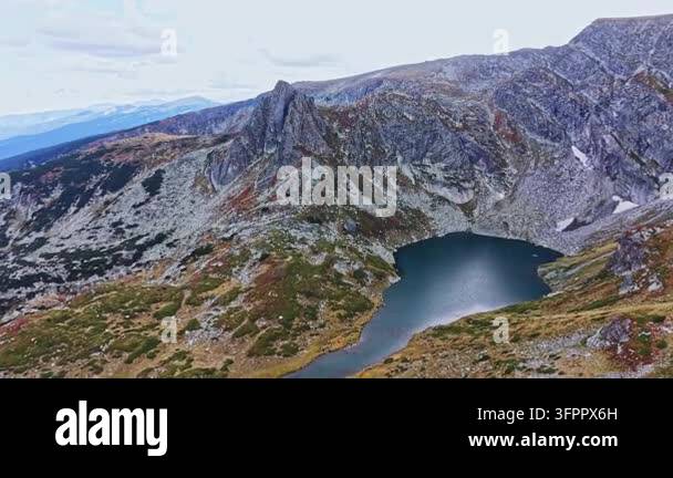 Large Area A large rocky area features a lake at its base. Mountains surround the ...