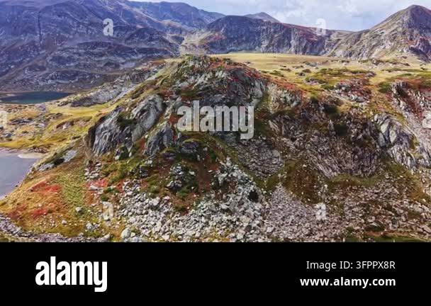 Large Area The scene shows a large rocky area on a mountain with patches of ...