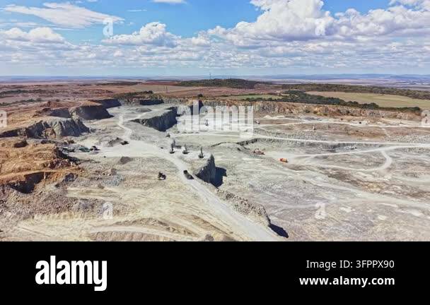 Large Area Granite quarry site with multiple workers operating heavy machines ...