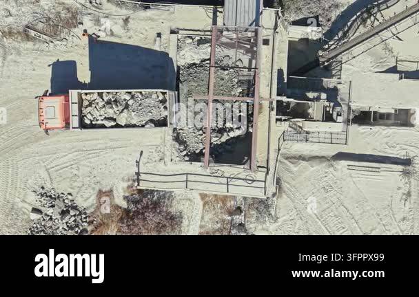 Loading Vehicle Vector A truck waits as workers load granite from a processing area in a ...