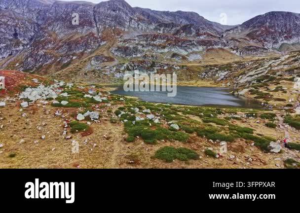 Html Olors A lake sits in the valley surrounded by rocky mountains and patches of ...