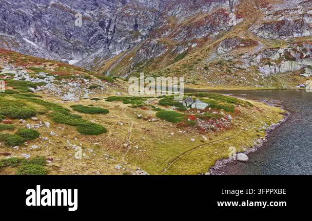 Html Olors A valley with green bushes and rocky areas is nearby a body of water ...