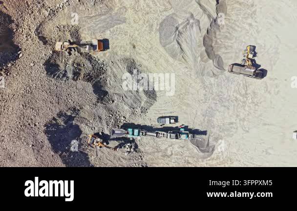 Large Area Heavy machinery is working at a granite quarry. Trucks and excavators ...