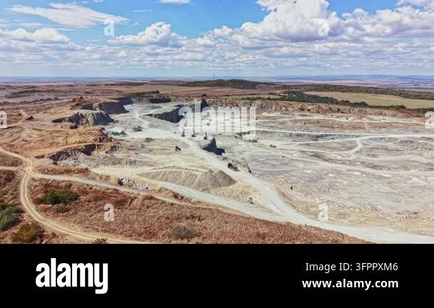Large Area Workers are operating machinery in a granite quarry located in a rural ...