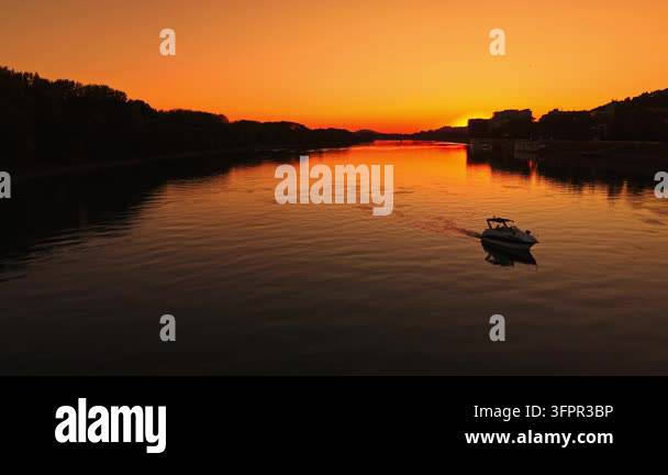 Html Olors A boat moves on the water as the sun sets, creating warm colors in the ...
