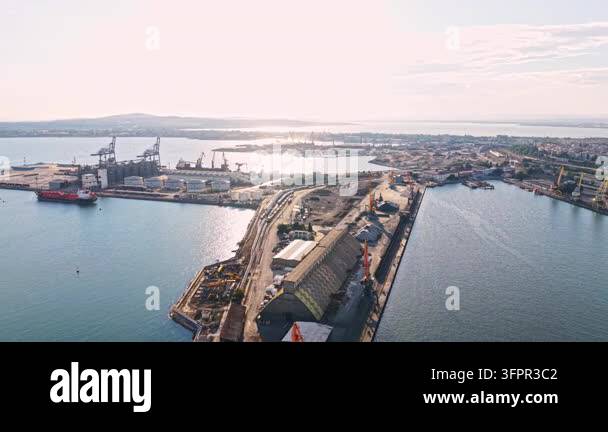 Large Area A large port is visible with ships docked along the water. Cranes are ...