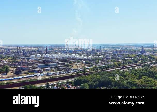 Large Area An industrial area with large factories, storage tanks, and smoke in ...