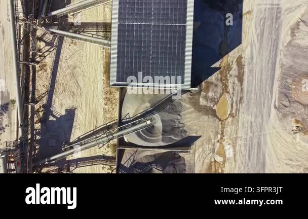 Pilling Rigg The scene shows solar panels on a roof with sand piles below. Equipment ...