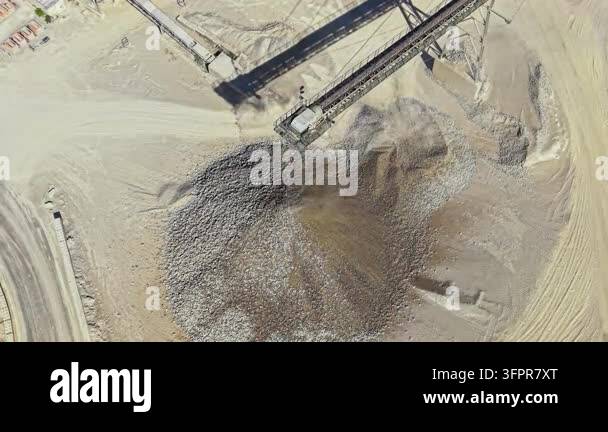 Pilling Rigg A large machine operates at a stone quarry, pouring rocks onto a pile ...