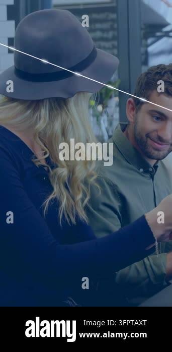 Vertical video: Woman showing phone to man in cafe while sharing, blue ...