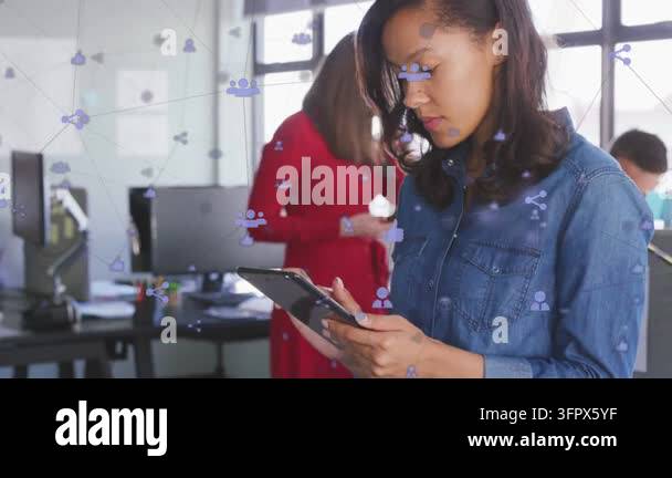 Woman tapping tablet and scrolling in office, social icons linking team ...