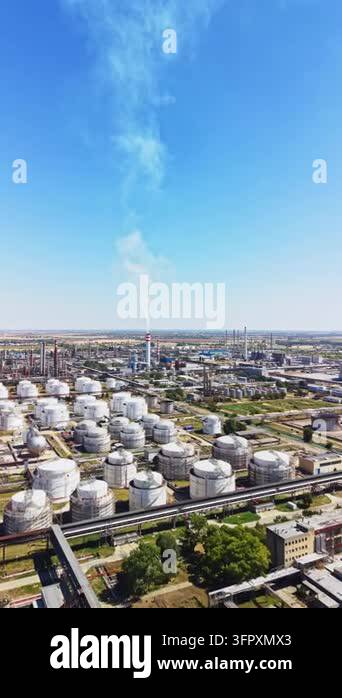 An industrial area features large storage tanks and multiple factory ...