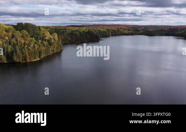 Wide aerial panorama of a serene lake nestled inside a multicolored ...