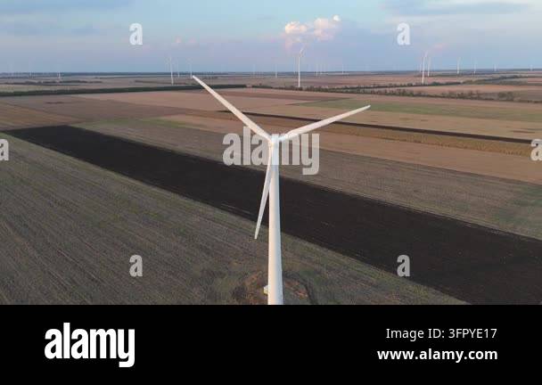 Top view of wind turbine with rotating blades above agricultural field ...