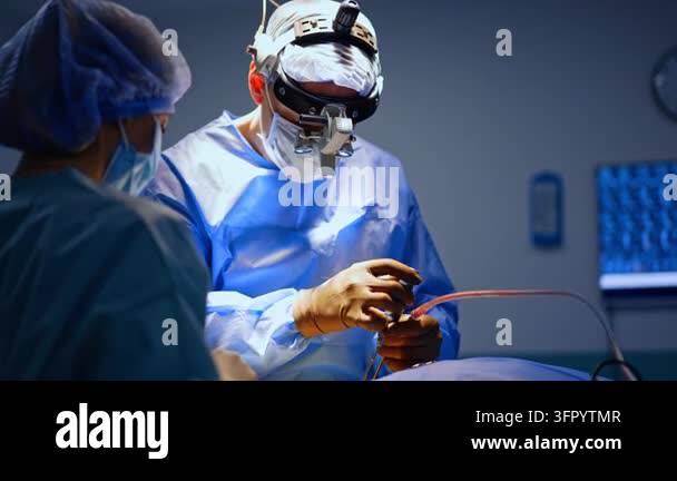 Medical Instrument Signage Male doctor wearing surgical loupes uses tools at neurosurgery. Female ...
