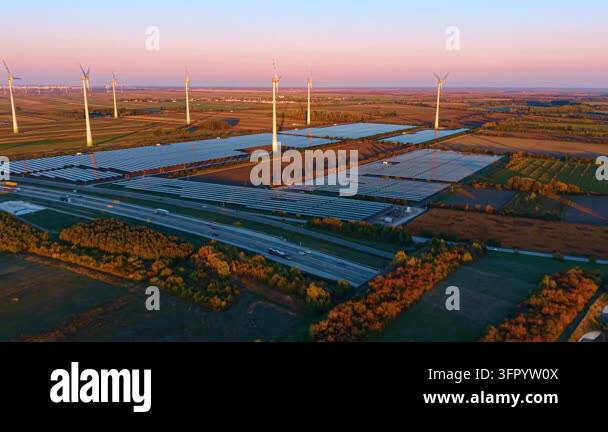 Solar arrays and wind turbines, aerial view beside a divided highway ...