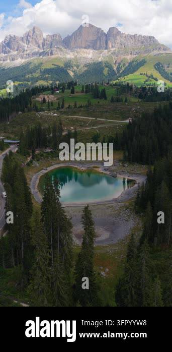 Hovering aerial view over emerald forest lake reflecting trees beneath ...