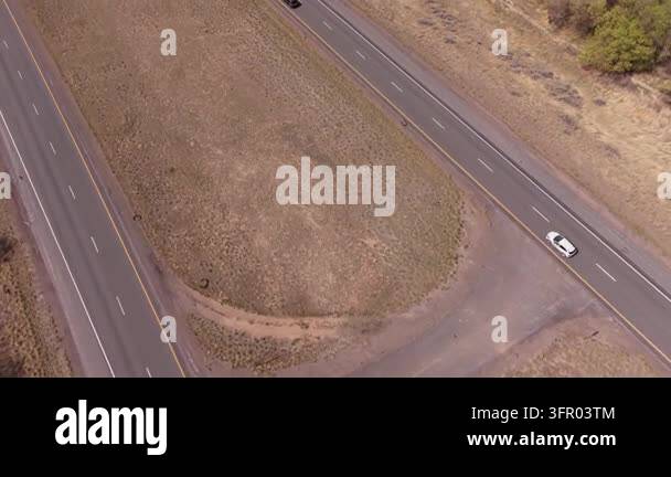 An aerial top down view of a two lane highway in rural Utah. Cars drive ...