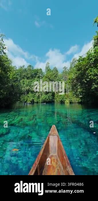 Pov of a traditional wooden boat floating on a pristine turquoise lake ...