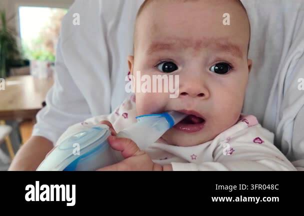 Baby Using Inhaler Cute 6-7 month old baby holding inhaler mask with small hands while ...