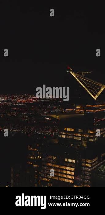 Vertical video: Forwards fly to modern tall skyscraper with sky deck ...