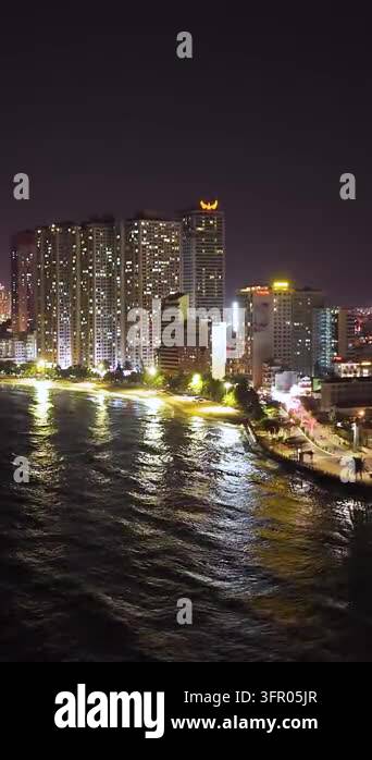 Waterfront High Rises Illuminated high-rise buildings and a waterfront promenade reflect ...