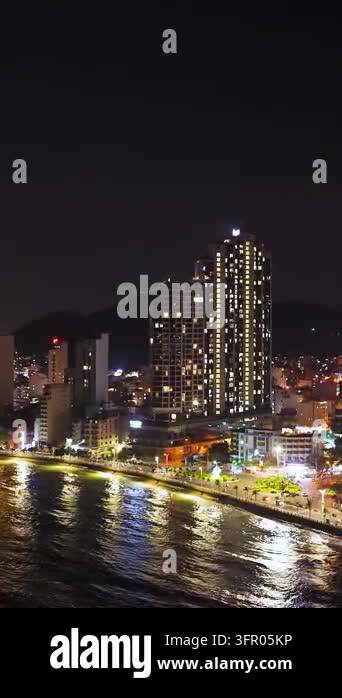 Waterfront High Rises Illuminated high-rise buildings and a busy waterfront promenade reflect ...