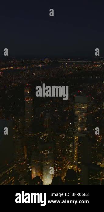 Vertical video: Descending footage of illuminated tall office towers in ...