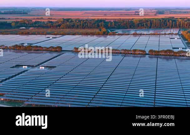 Solar panel rows surround access tracks and equipment boxes. Blue ...