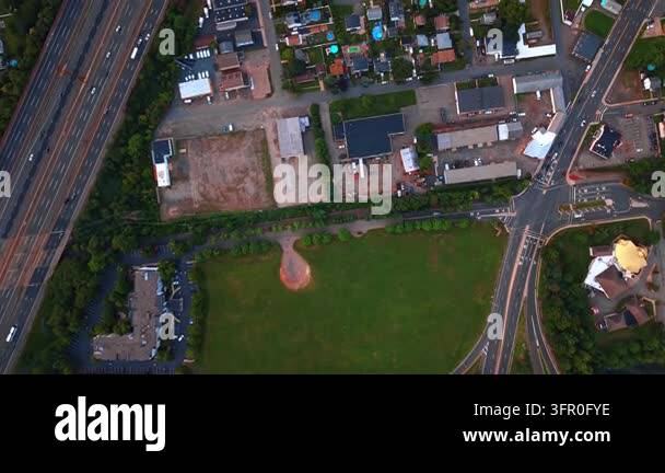 Rural residential area enclosed between roads. Numerous cars move by ...