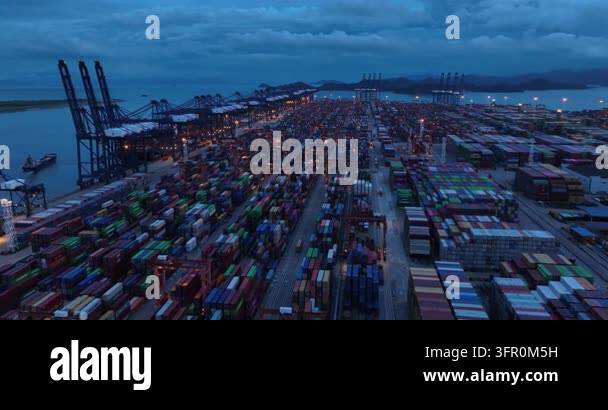 Aerial view of a massive container port at dusk with numerous shipping ...