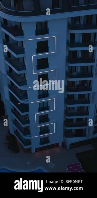 Aerial view of a modern residential building with balconies and glowing ...