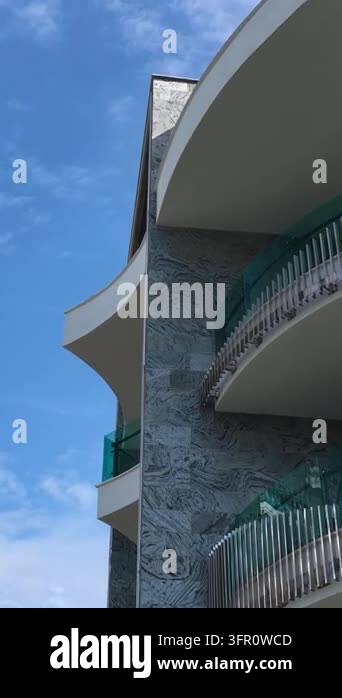 Structural Frame Corner Upward view of curved balconies, textured stone walls, and railings ...