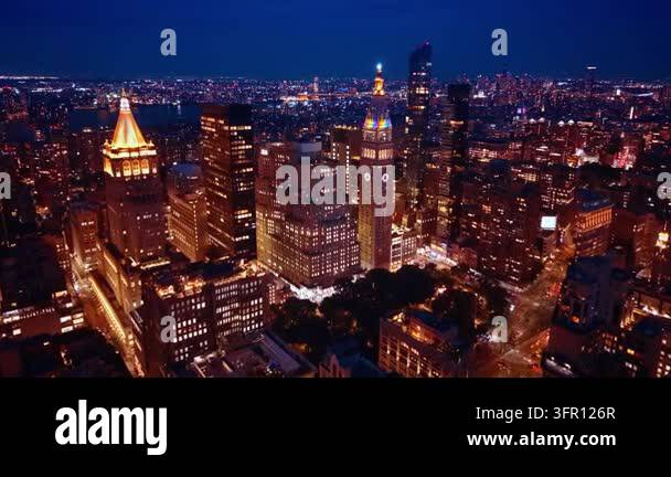 Madison Square Park and surrounding towers at night. Lit streets border ...